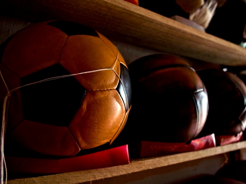 Balón clásico de 32 paneles en cuero reposando en repisa de madera